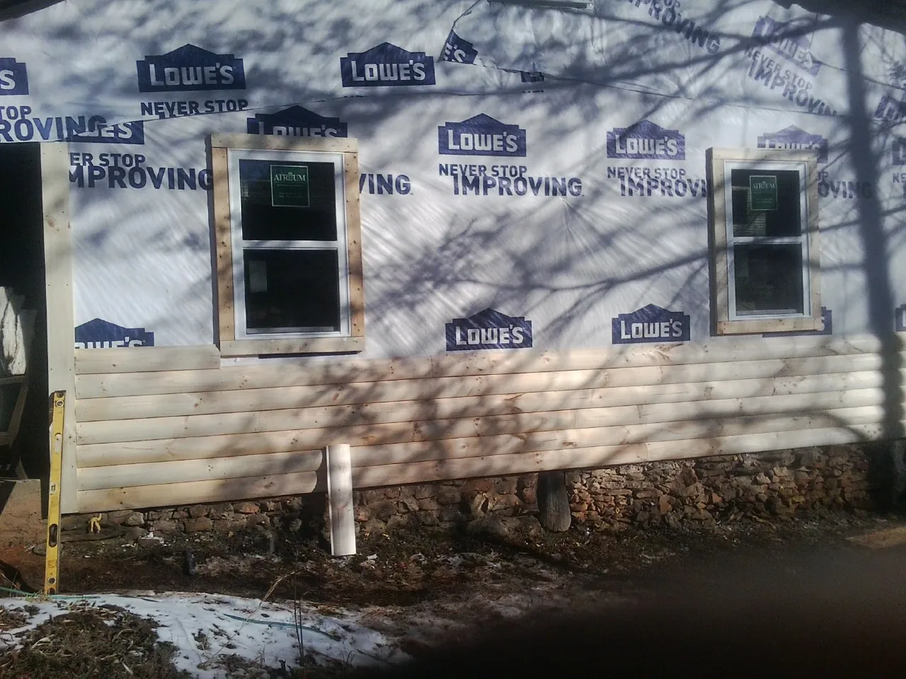 House wrap and new log siding going up on an exterior wall in Cleveland